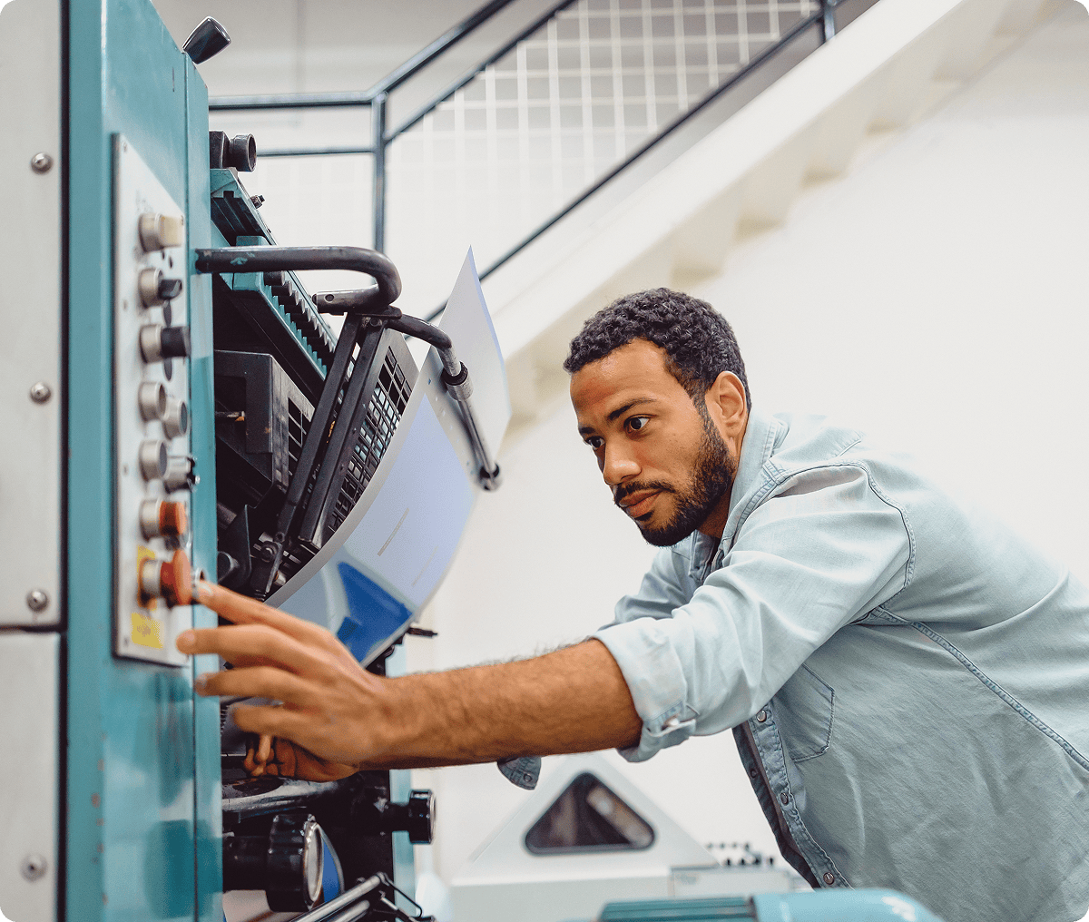Man operating industrial printing machine.