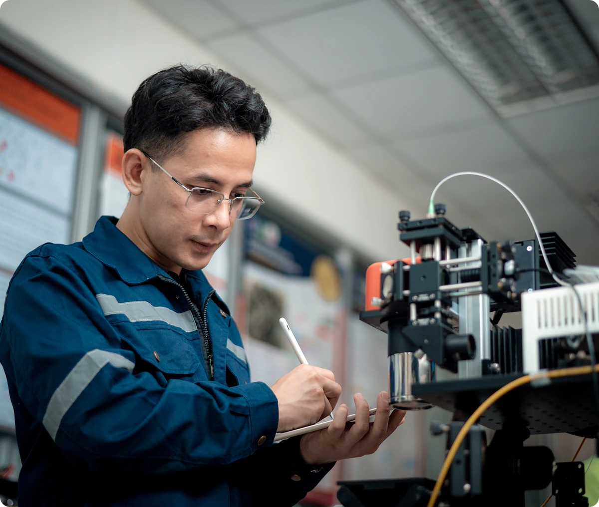 Person taking notes near a 3D printer.