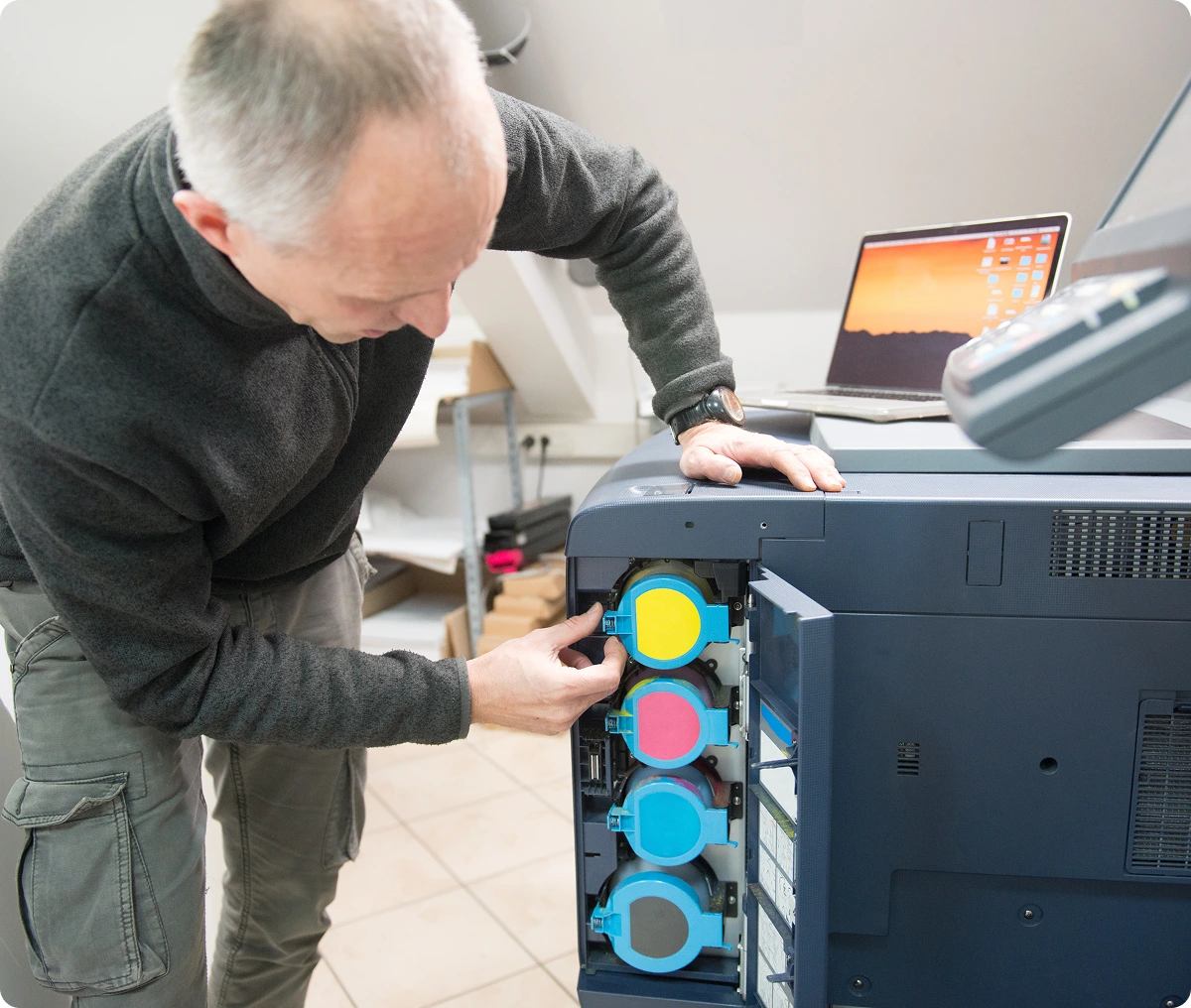 Man replacing printer toner in office.