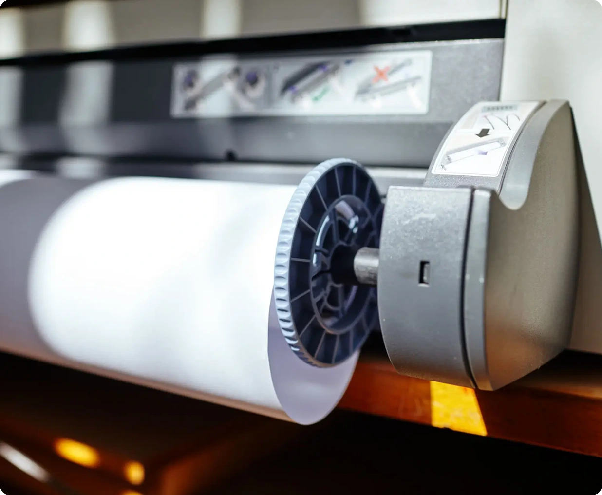 Large format printer with paper roll.